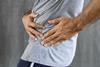 A man holds his left hip in pain