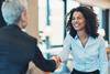 Two business women shake hands