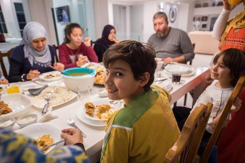shutterstock_ happy little kid eating with his family