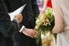 An officiant conducts a wedding ceremony with a bride and groom