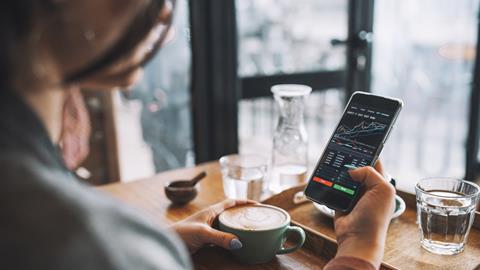 A woman looks at a stocks graph in a coffee shop