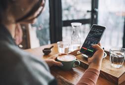A woman looks at a stocks graph in a coffee shop